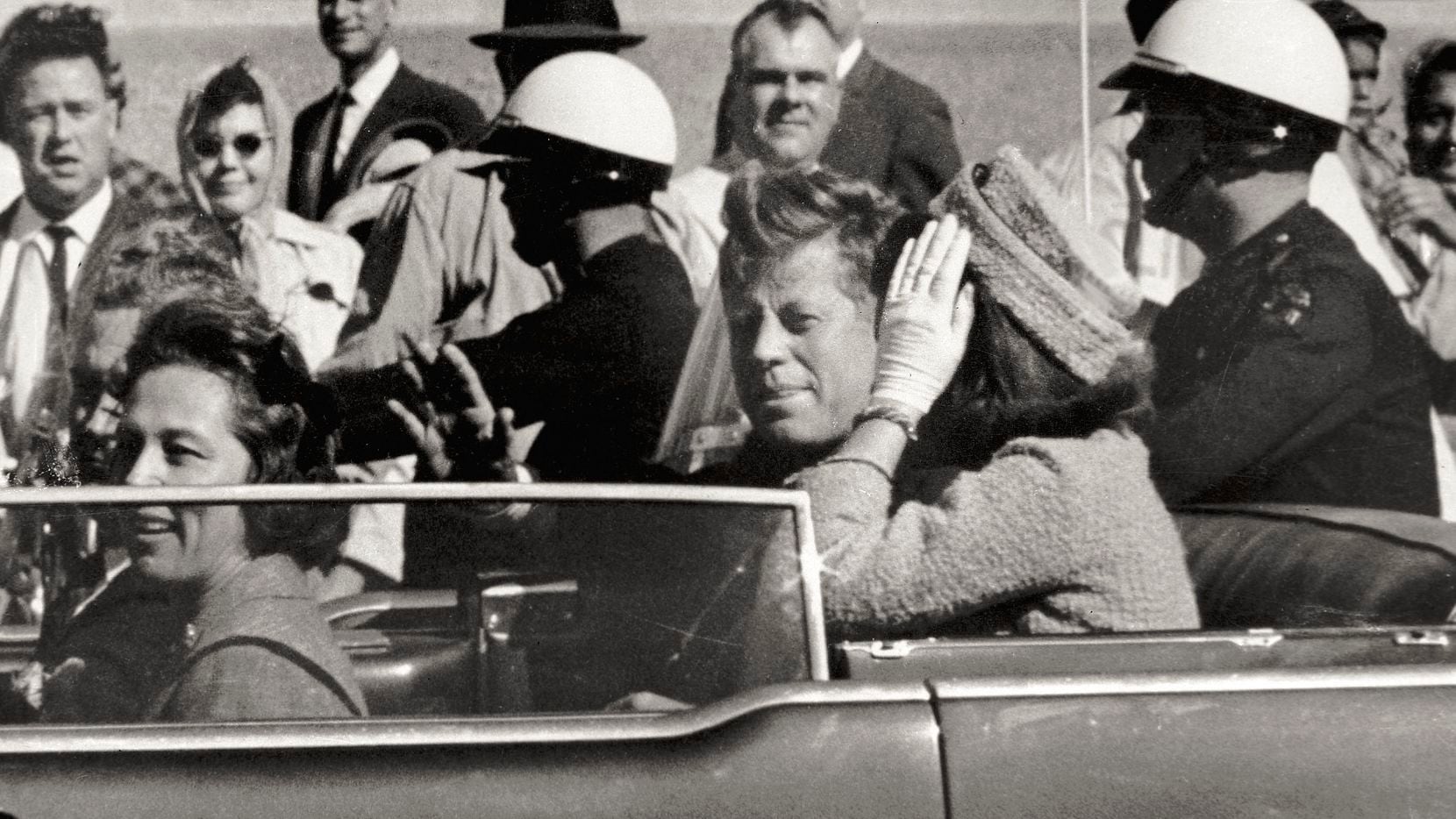In this Nov. 22, 1963 file photo, President John F. Kennedy waves from his car in a...