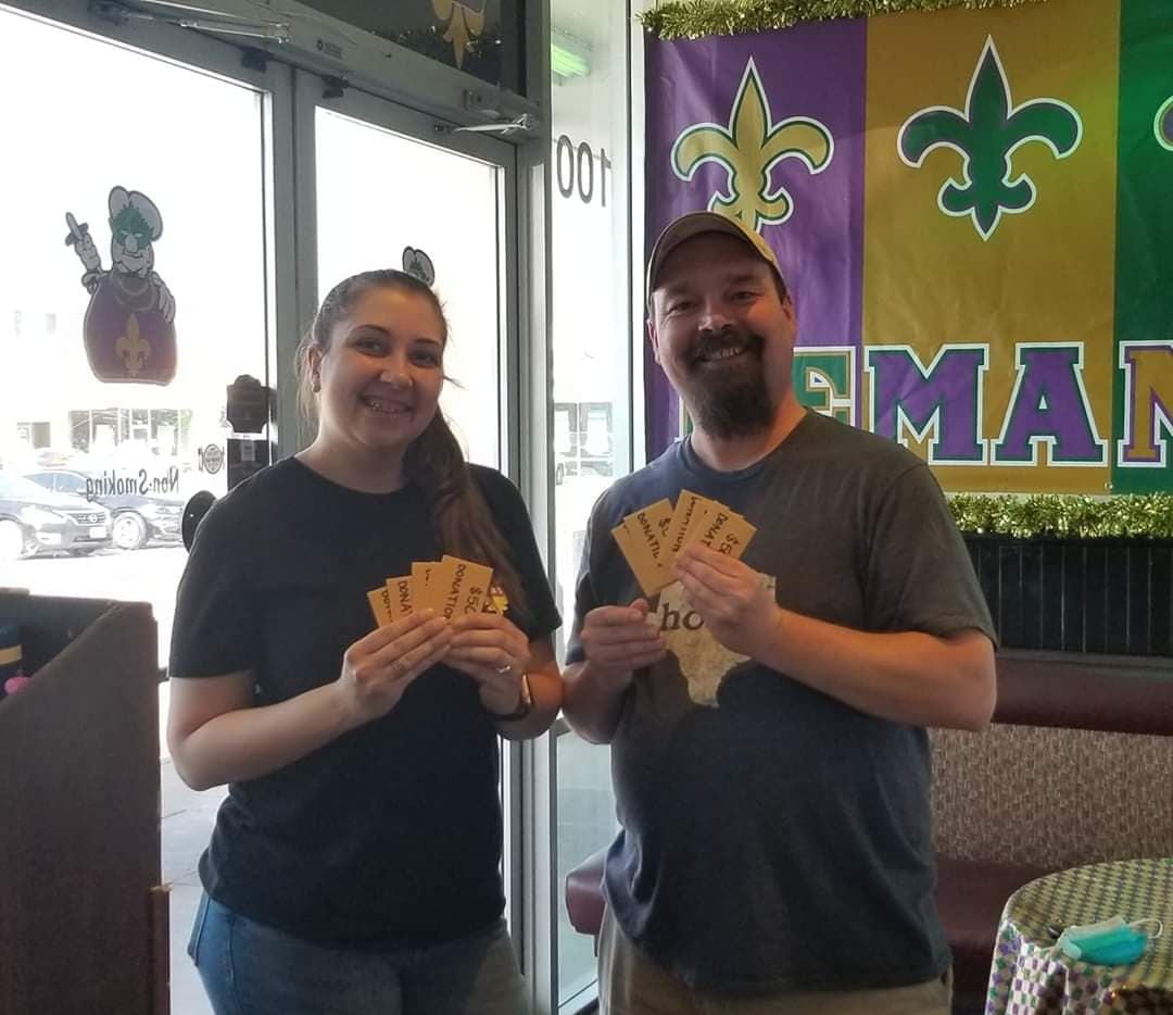 Ciara Ronasi, an employee at Po' Melvin's, and Mark McKee hold gift cards inside the restaurant.