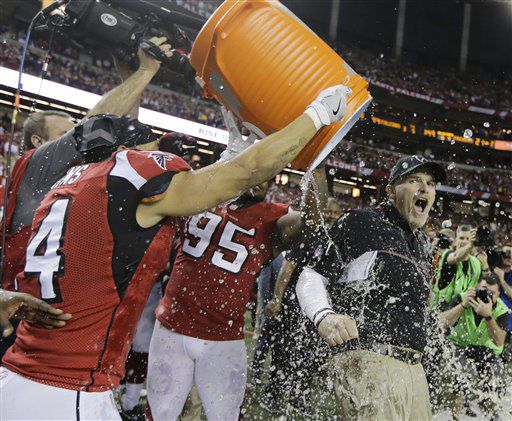 Dan Quinn, entrenador de los Falcons de Atlanta, es bañado con la hielera tras la victoria...