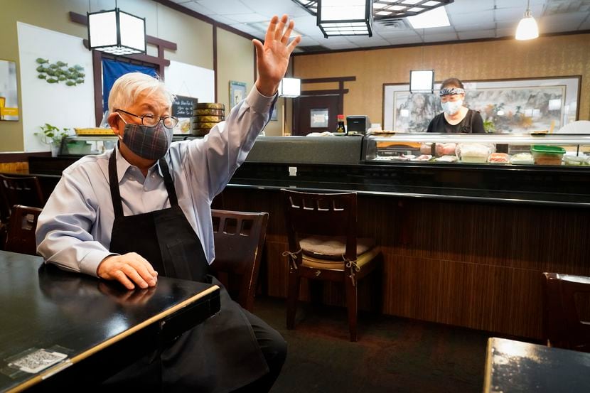 Sushiya restaurant owner Kang Lee waved to a departing customer as Junok Kim worked the...