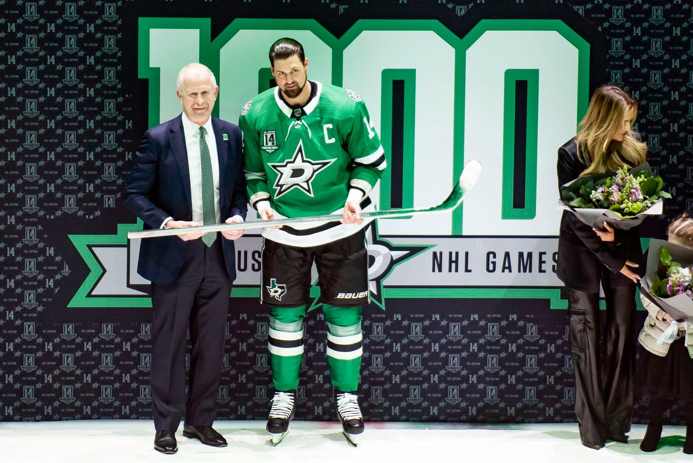 Dallas Stars left wing Jamie Benn (14) is presented with a silver stick by Stars general...