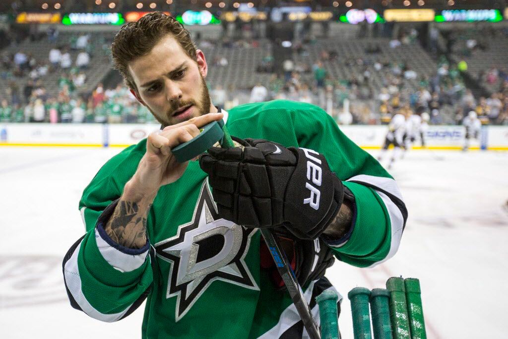Dallas Stars center Tyler Seguin tapes his stick as the teams warm up befor...