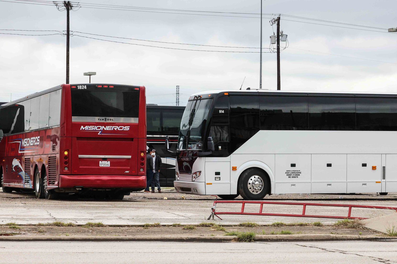 Charter buses and white vans gather at Hotel Street parking lot behind the Kay Bailey Hutchison Convention Center where teen migrants are being housed in Dallas on Wednesday, May 12, 2021. 