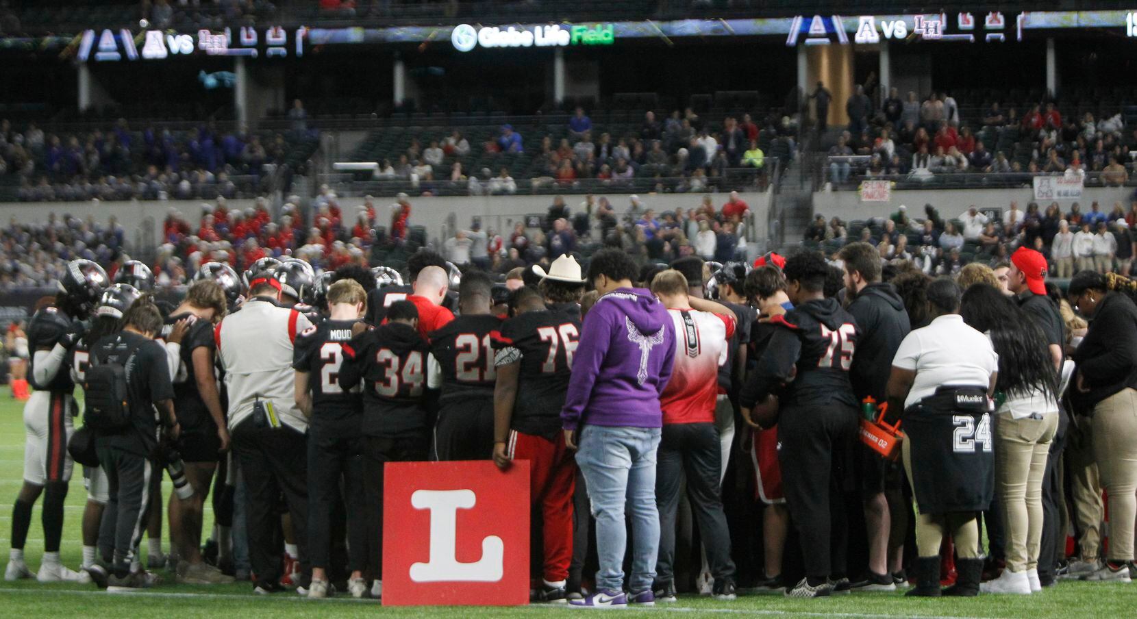 Lake Highlands players and coaches pause for a prayer for defensive back Shamar Donaldson...