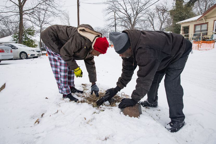 Patricia Broadway (left) and Leon Morris put the cover back after shutting the water off in...