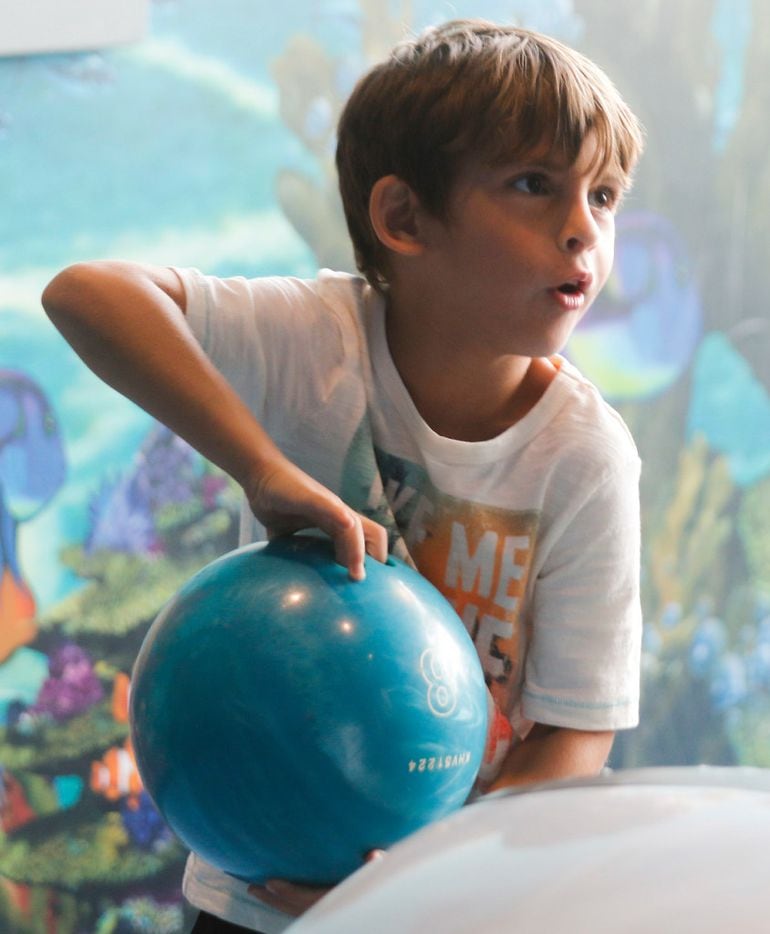 Jeremy Goldwyn reacts at the weight of a bowling ball while bowling at the Children's...