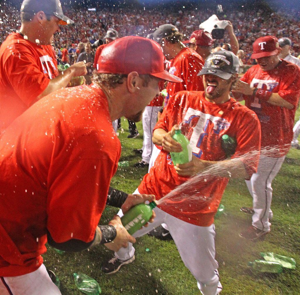 Texas P C.J. Wilson, right, squirts OF Josh Hamilton, left, with ginger ale after Game 6 of...