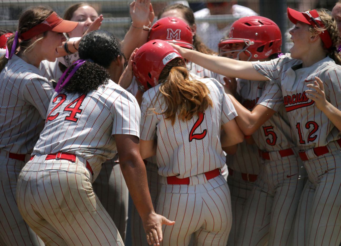 The team celebrates at home plate as Flower Mound Marcus High School player #2, Makayla...
