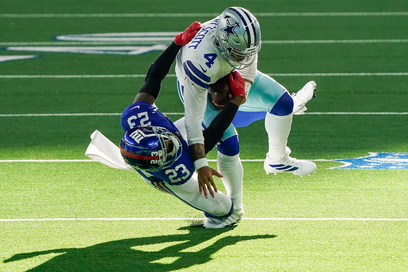 Dallas Cowboys quarterback Dak Prescott (4) is brought down by New York Giants cornerback...