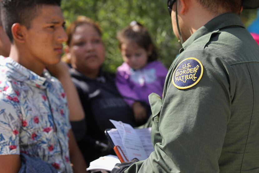 Un agente de la Patrulla Fronteriza interroga a un grupo de inmigrantes de Centroamérica que...