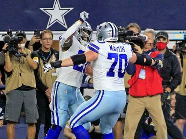 Dallas Cowboys running back Ezekiel Elliott (21) and teammate Zack Martin (70) celebrate...