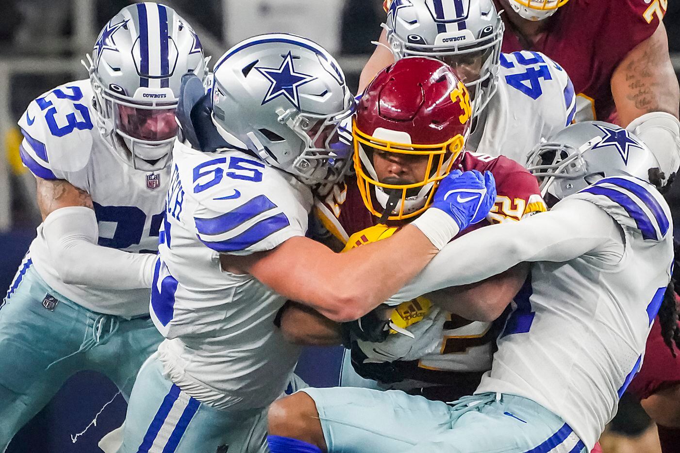 Washington Football Team running back Jaret Patterson (32) is brought down by Dallas Cowboys outside linebacker Leighton Vander Esch (55), cornerback Maurice Canady (31), middle linebacker Keanu Neal (42) and defensive back Darian Thompson (23) during the second half of an NFL football game at AT&T Stadium on Sunday, Dec. 26, 2021, in Arlington. The Cowboys won the game 56-14.
