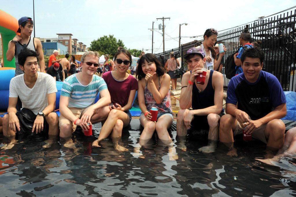 Friends wade in the pool at the Deep Ellum Water Balloon Wars in Deep Ellum, Texas on August...