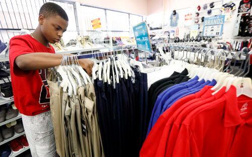 Alex Atkins, 13, busca unos pantalones que combinen con su uniforme escolar en una tienda de...