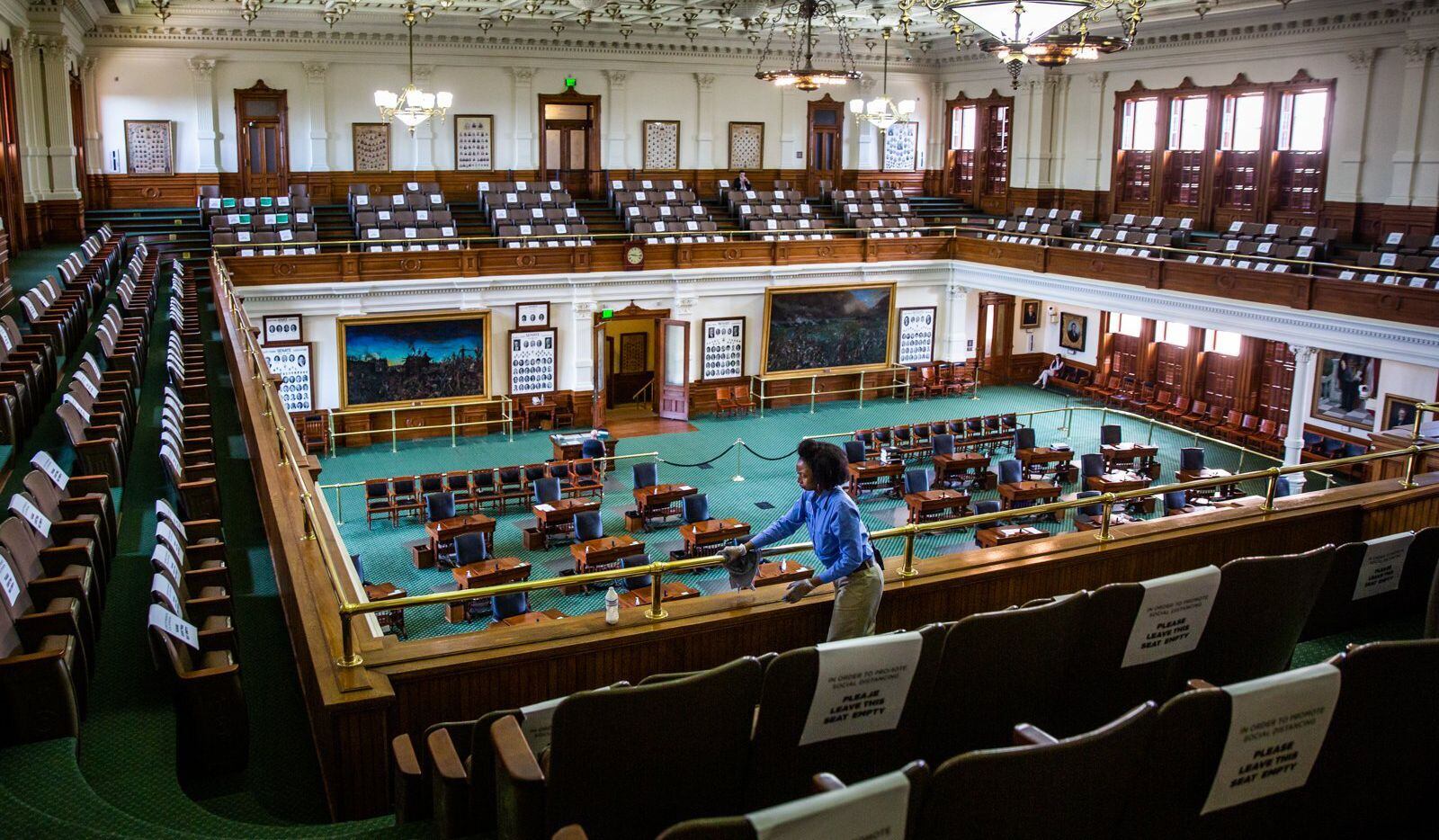 Capitol staff member Ollie Vaughn polishes the railings in the empty Texas Senate Chamber on...
