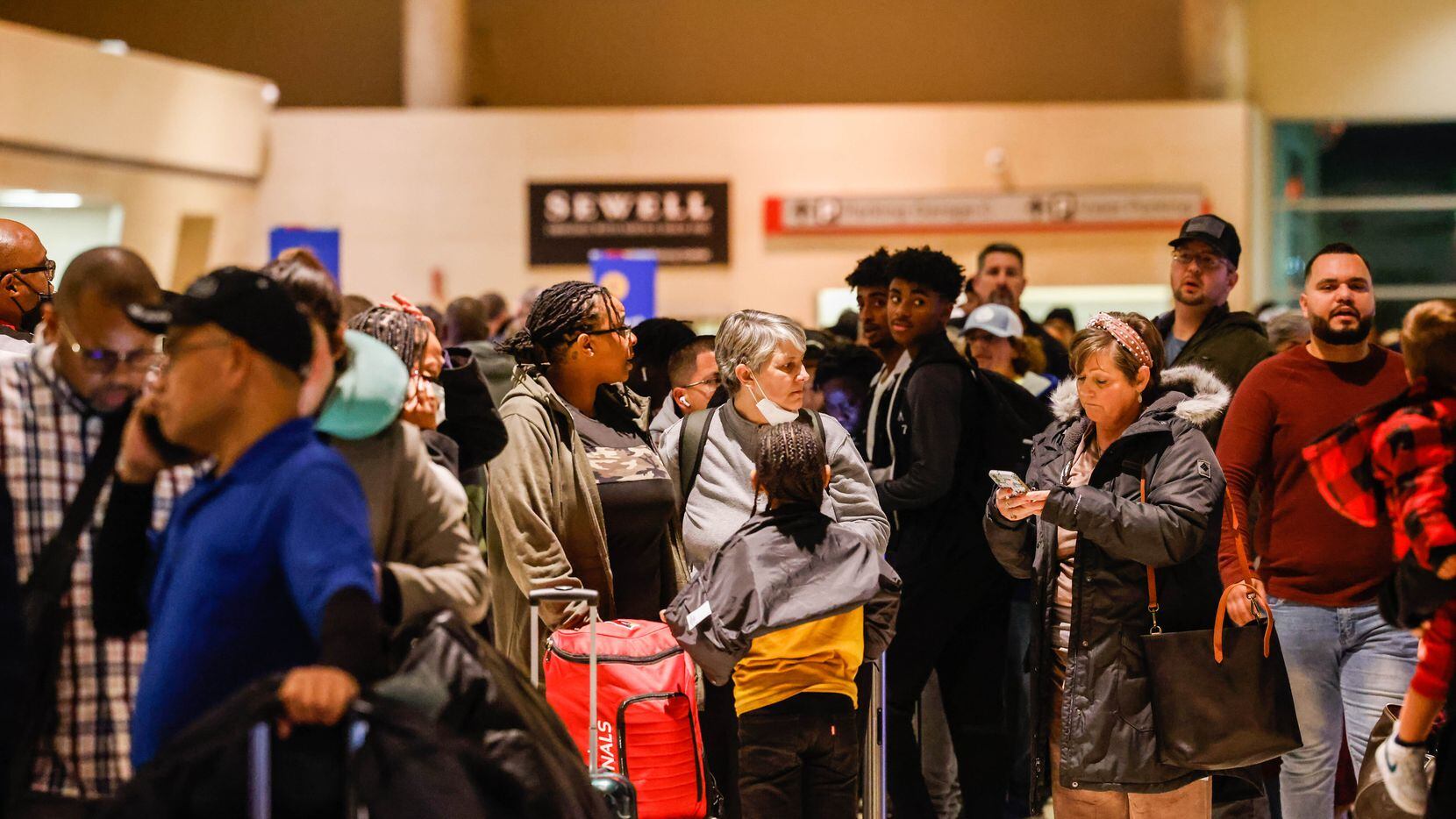 Travelers wait in line to be served by Southwest customer service staff after most flights...