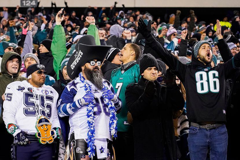 Fanáticos de los Eagles de Filadelfia celebran mientras dos fanáticos de los Dallas Cowboys...
