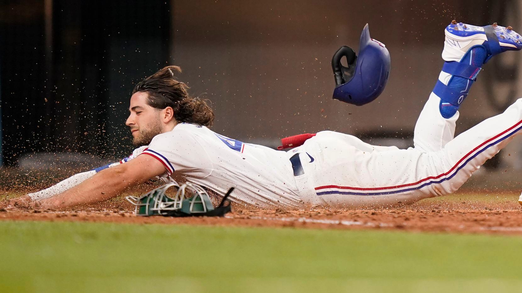 Texas Rangers Josh Smith slides safely into home plate for an inside-the-park home run...