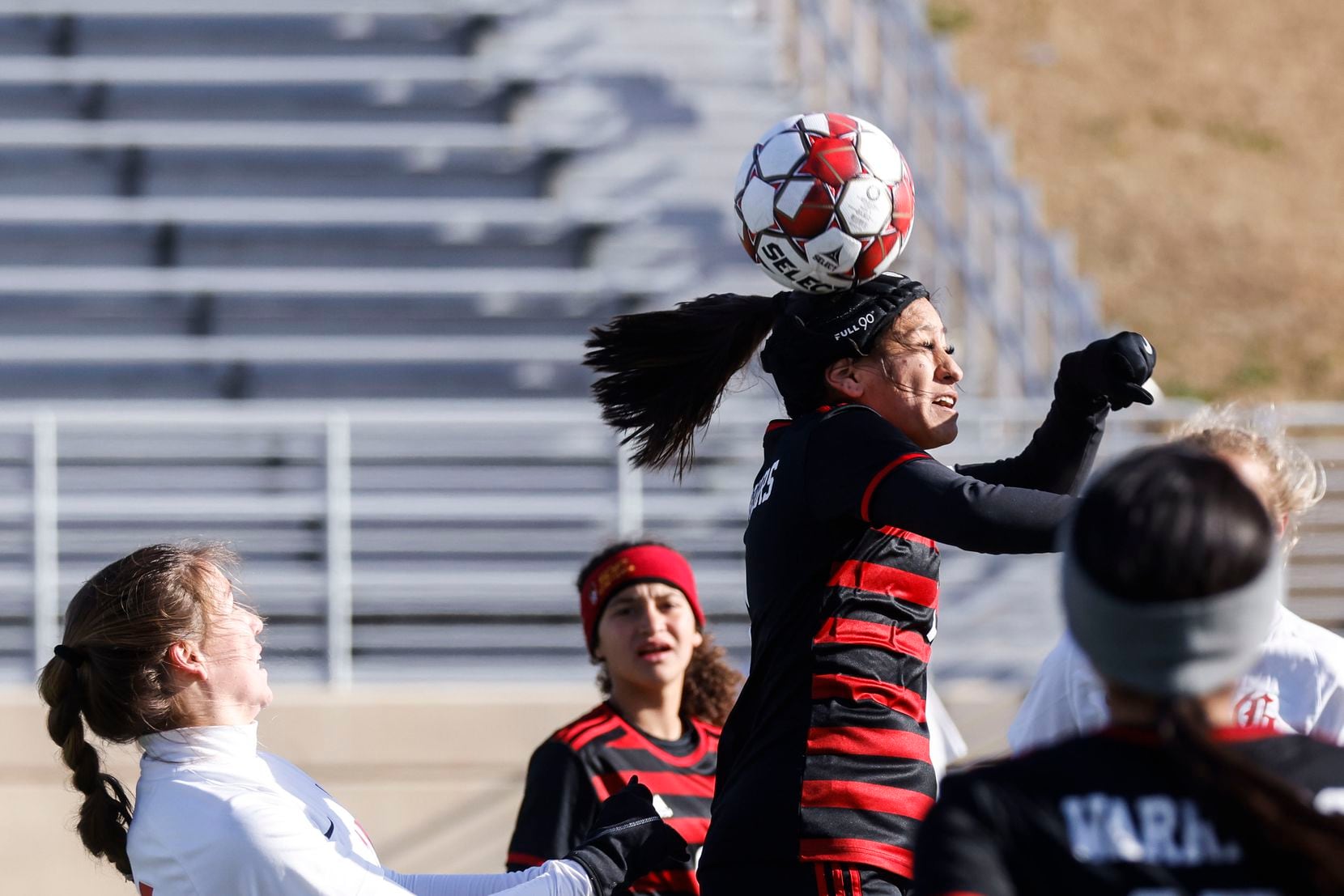 South Grand Prairie High School’s Natalie Lopez, center, heads the ball against Grapevine...