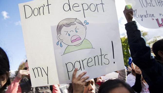 
				Una mujer sostiene una pancarta durante una protesta en contra de las deportaciones en...
