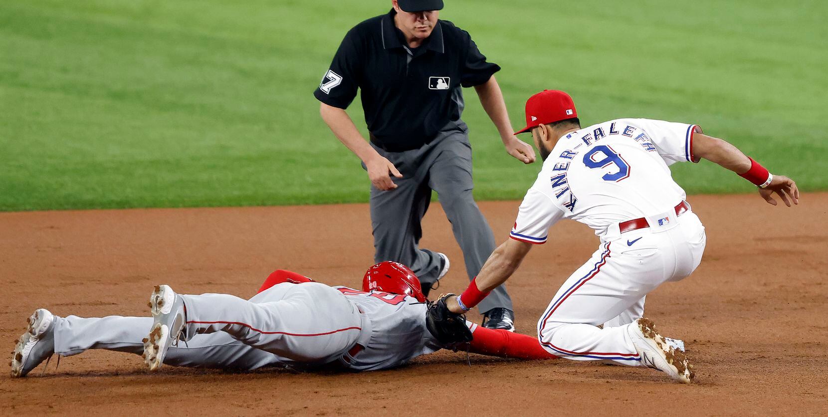 Los Angeles Angels Jared Walsh (20) dives back to second as Texas Rangers shortstop Isiah Kiner-Falefa (9) attempts the tag during the first inning at Globe Life Field in Arlington, Texas, Wednesday, April  28, 2021. Walsh was trying to advance on a two-RBI single by Anthony Rendon. (Tom Fox/The Dallas Morning News)
