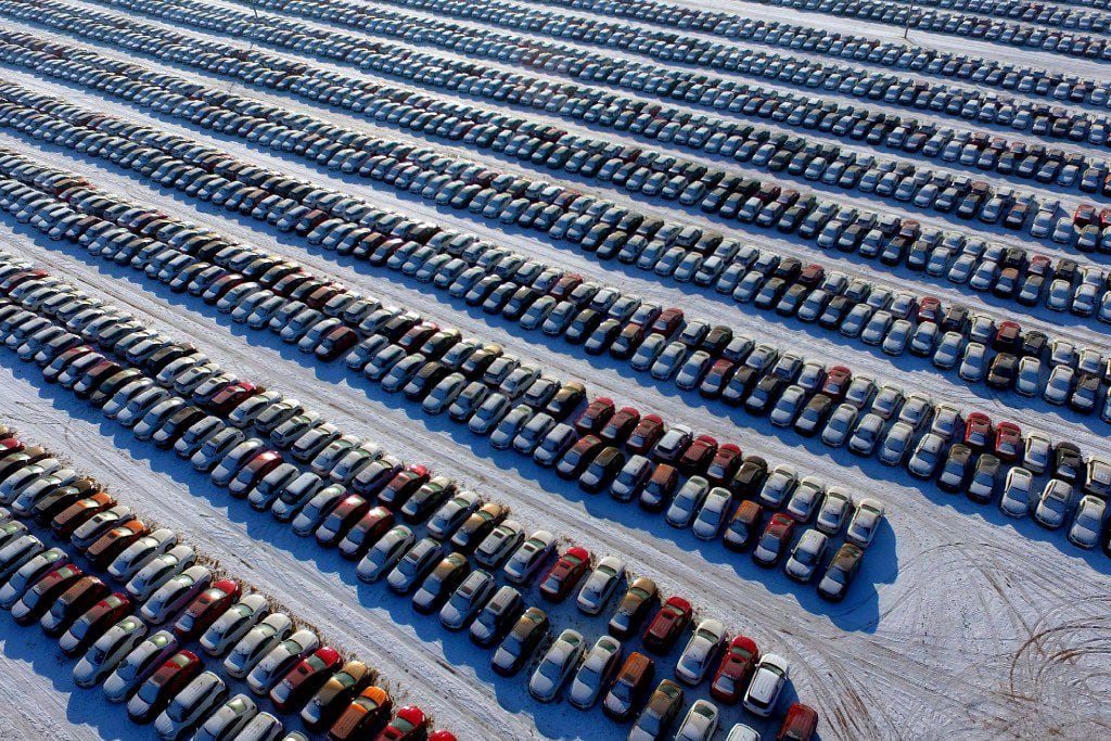 This aerial photo taken on January 16, 2017 shows new cars lined up at a parking lot in...