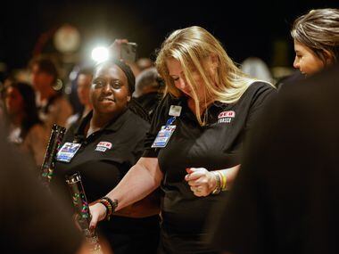 H-E-B worker Cindy Flach, left, dance next to they coworker Krissy Crump as they prepare to...