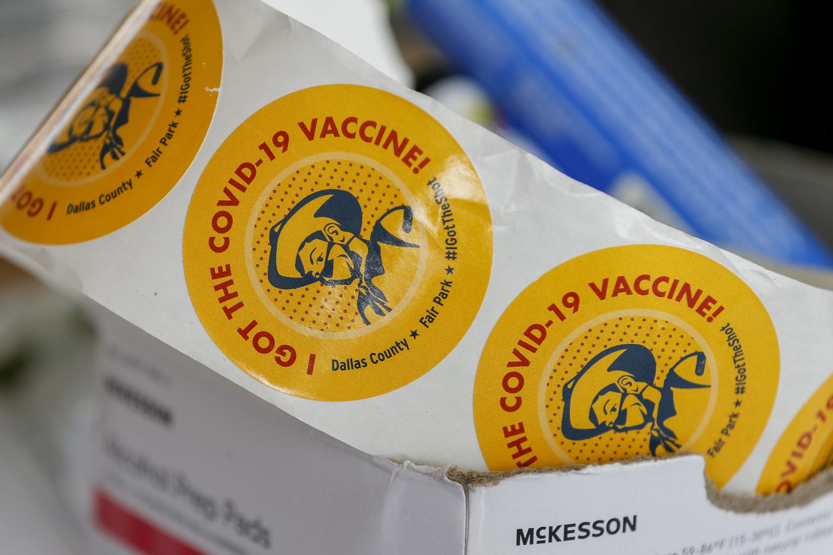 Vaccination stickers bearing a masked Big Tex sat unused on a table on the last day, among...