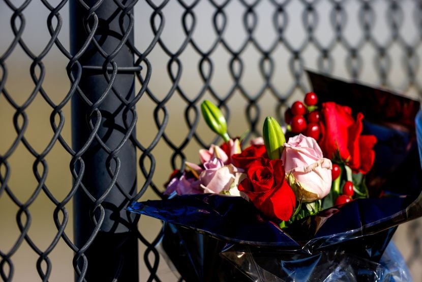 Flowers are left along the fenceline of the Dallas Executive Airport on Sunday, Nov. 13,...