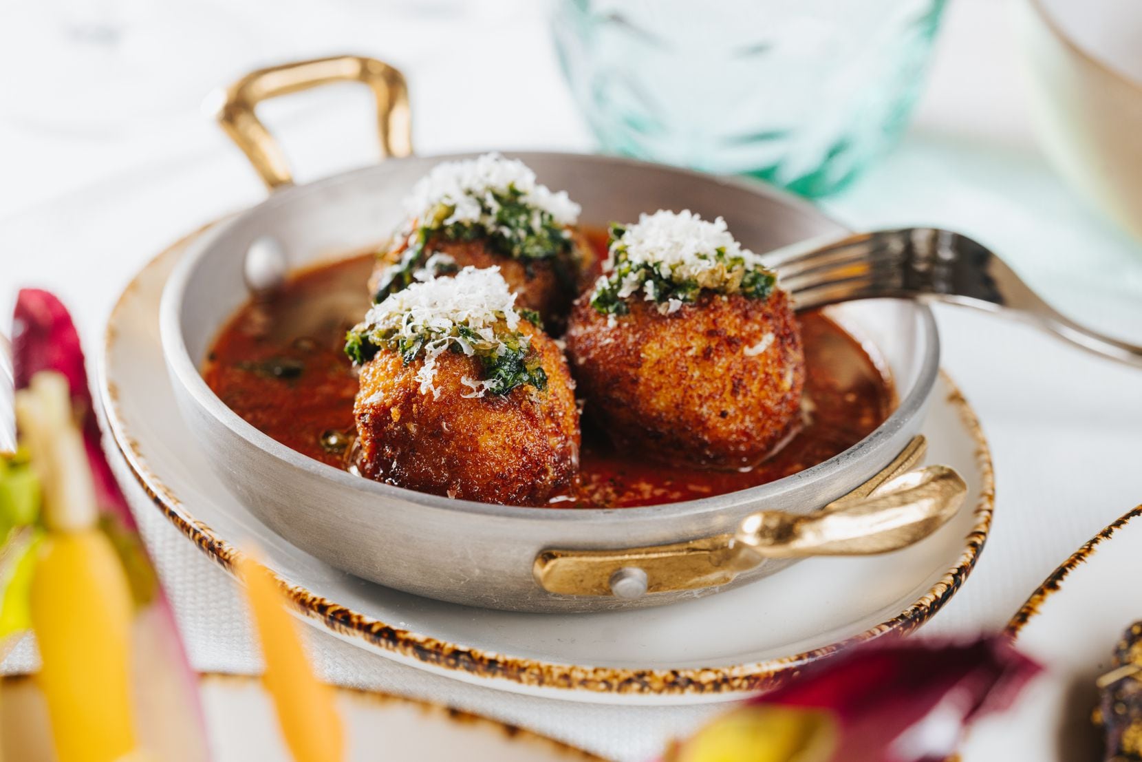 The arancini at 61 Osteria in Fort Worth is a blend of fontina cheese and rice, fried and...