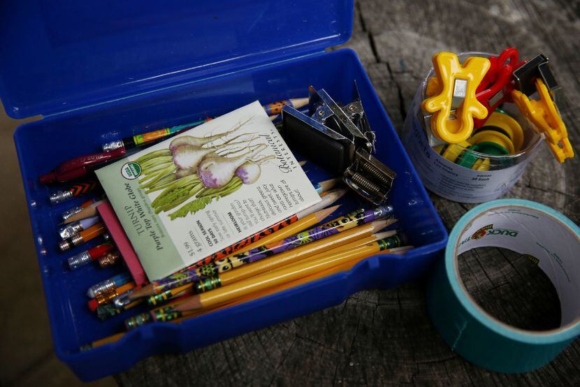 School supplies and seeds sit on a a stump under the outside classroom before Dayle...