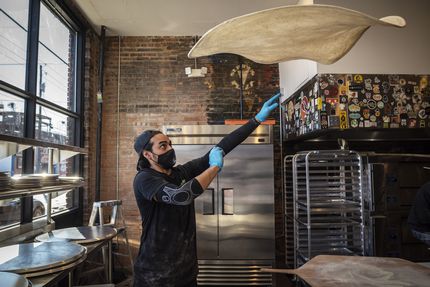 Restaurant manager Francisco Arrona tosses and stretches pizza dough at Serious Pizza in...