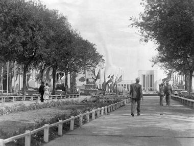 An undated photo of people strolling along the Esplanade with the Hall of State in the...