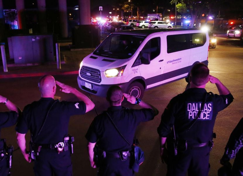 Policías de Dallas saludan a la van que transportaba a su compañero caído, Rogelio...