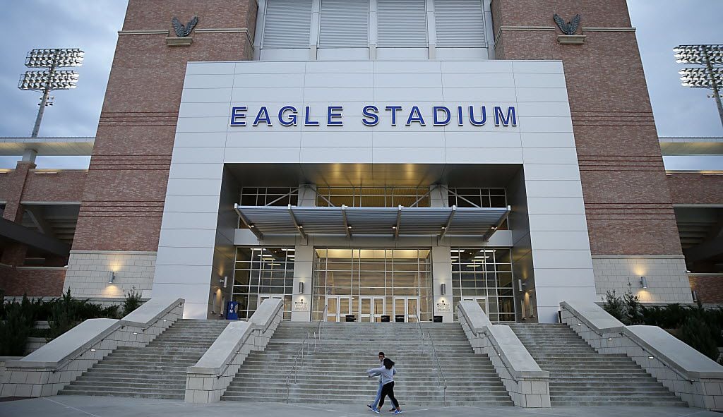 Two football fans walk by the Eagle Stadium prior to the Allen vs. Plano East game on Friday, Nov. 6, 2015, in Allen, Texas.