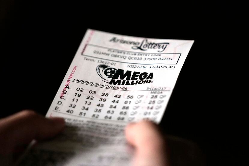 Una persona sostiene un boleto de la lotería Mega Millions en Tempe, Arizona, el 30 de...