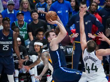 Dallas Mavericks guard Luka Doncic (77) scores over Utah Jazz forward Bojan Bogdanovic (44)...