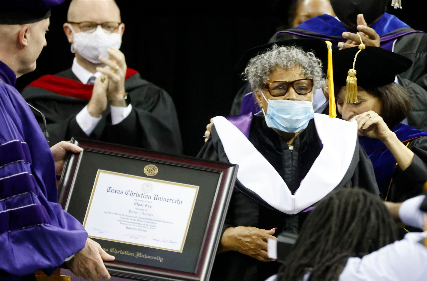 TCU Chancellor Victor J. Boschini Jr., left, and Provost Teresa Abi-Nader Dahlberg, right, presents Opal Lee, center, with an honorary Doctor of Letters at Commencement ceremonies in Fort Worth, Texas on Saturday, Dec. 18, 2021.