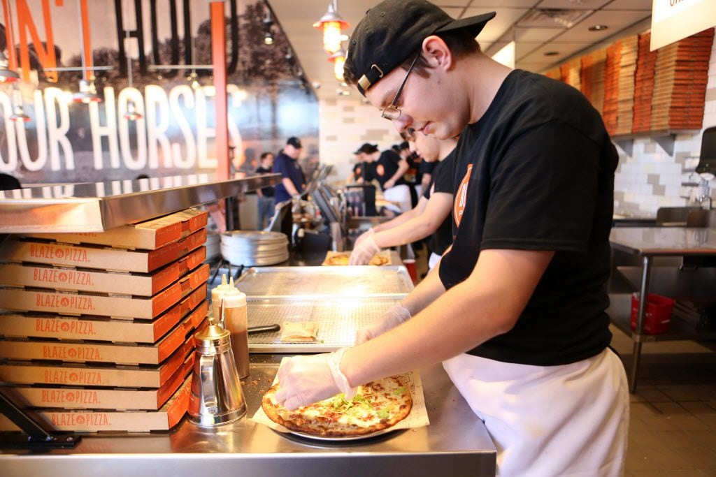 Kurtis Wilson slices a pizza fresh out of the oven at Blaze Pizza in Frisco.