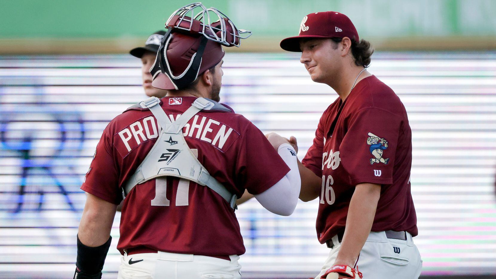 Texas Rangers prospect Owen White (right) is greeted by catcher Jordan Procyshen (17) after...