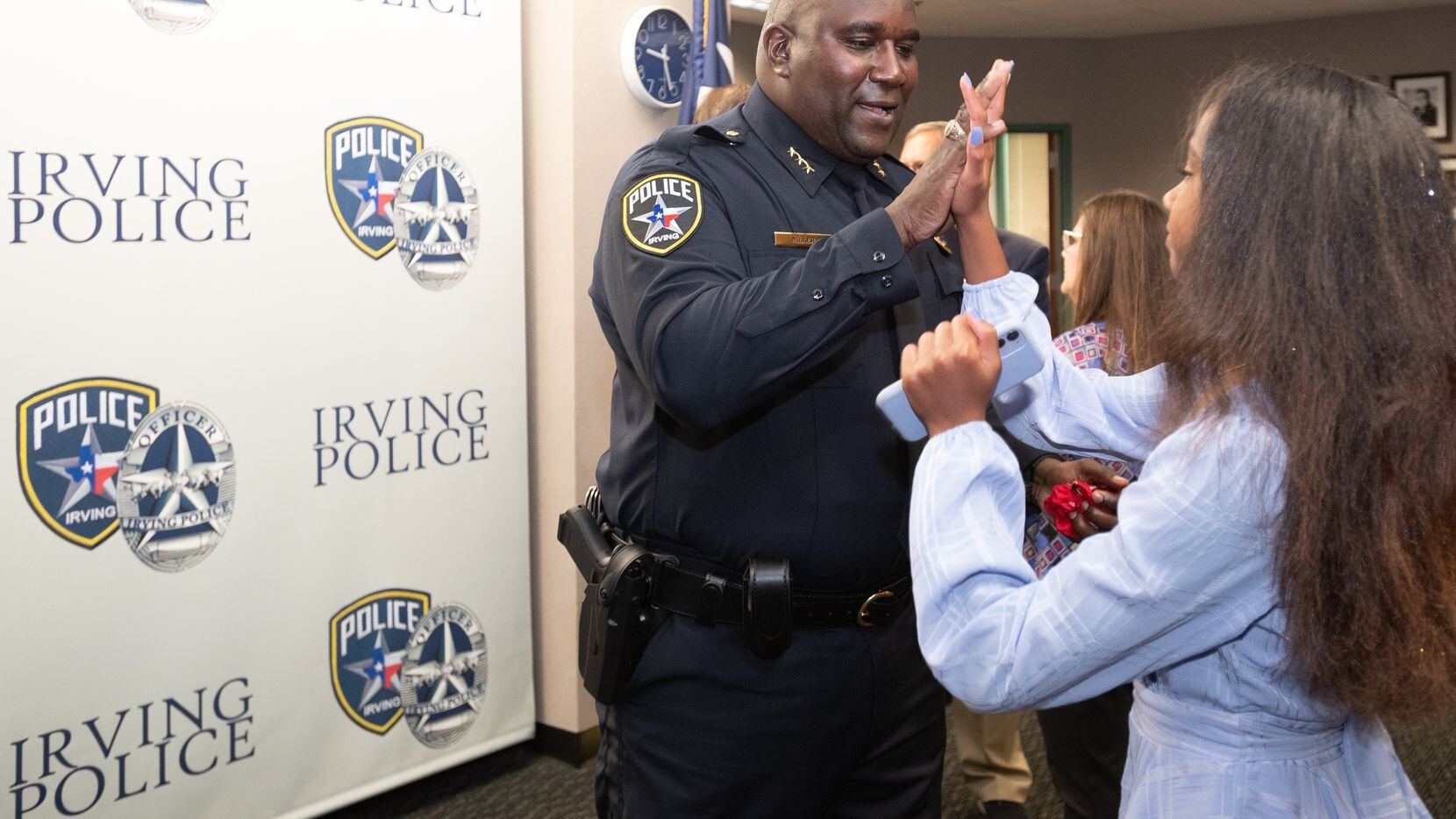 Irving police Chief Derick Miller high-fives his daughter Addison, 12, as she congratulates...