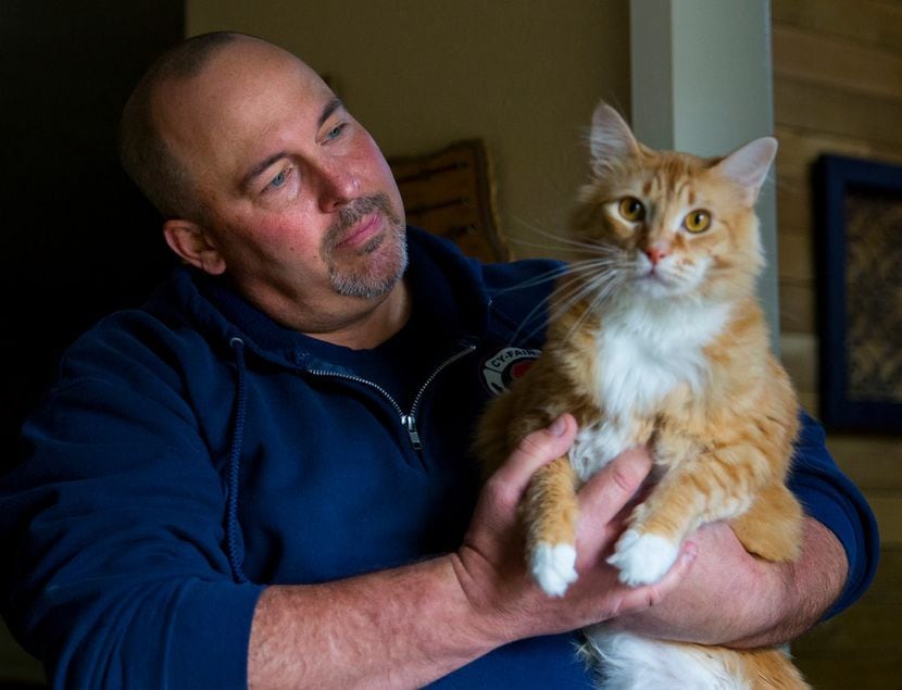 Richard Ford holds Jericho, the cat that belonged to his daughter, Desiree, in his home on...