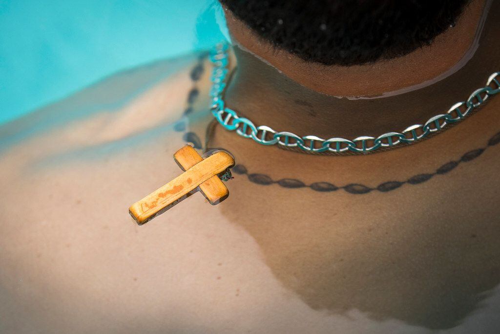 His cross float above his shoulders as Texas Rangers pitcher Alex Claudio during an...