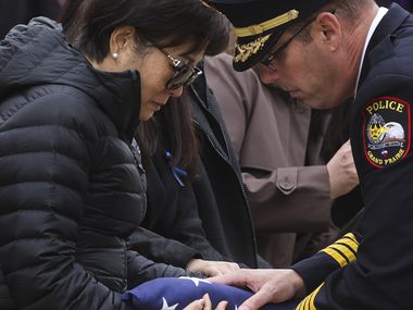 Ann Hsu, mother of  Grand Prairie police officer Brandon Tsai, is handed the American flag...