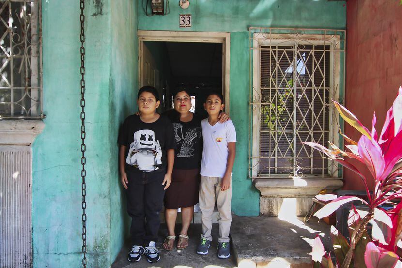 Flor Tovar y sus hijos Christian (derecha) y Oma Elias posan afuera de su casa en Ciudad...