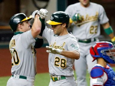 Oakland Athletics Matt Olson (28) is congratulated on his two-run homer by teammate Mark Canha (20) during the fourth inning against the Texas Rangers at Globe Life Field in Arlington, Texas,Tuesday, August 25, 2020.