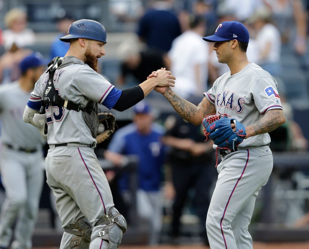 Texas Rangers relief pitcher Matt Bush, right, and catcher Jonathan Lucroy celebrate after...
