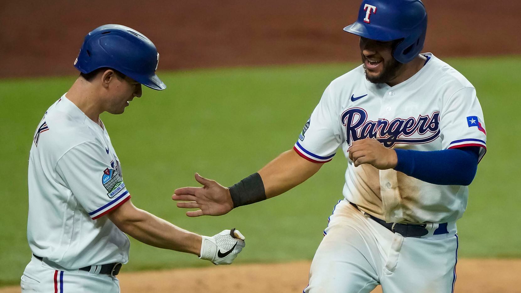 Catcher Jose Trevino (right) celebrates with Nick Solak after scoring a run in an intrasquad game during Texas Rangers Summer Camp at Globe Life Field on Saturday, July 18, 2020. 