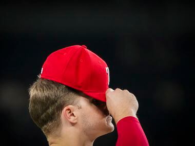 Texas Rangers third baseman Brock Holt adjusts his cap during the eighth inning against the...