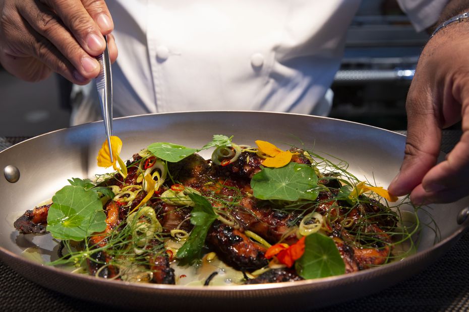Chef Junior Borges puts the final touches on grilled octopus at Meridian restaurant in 2021.